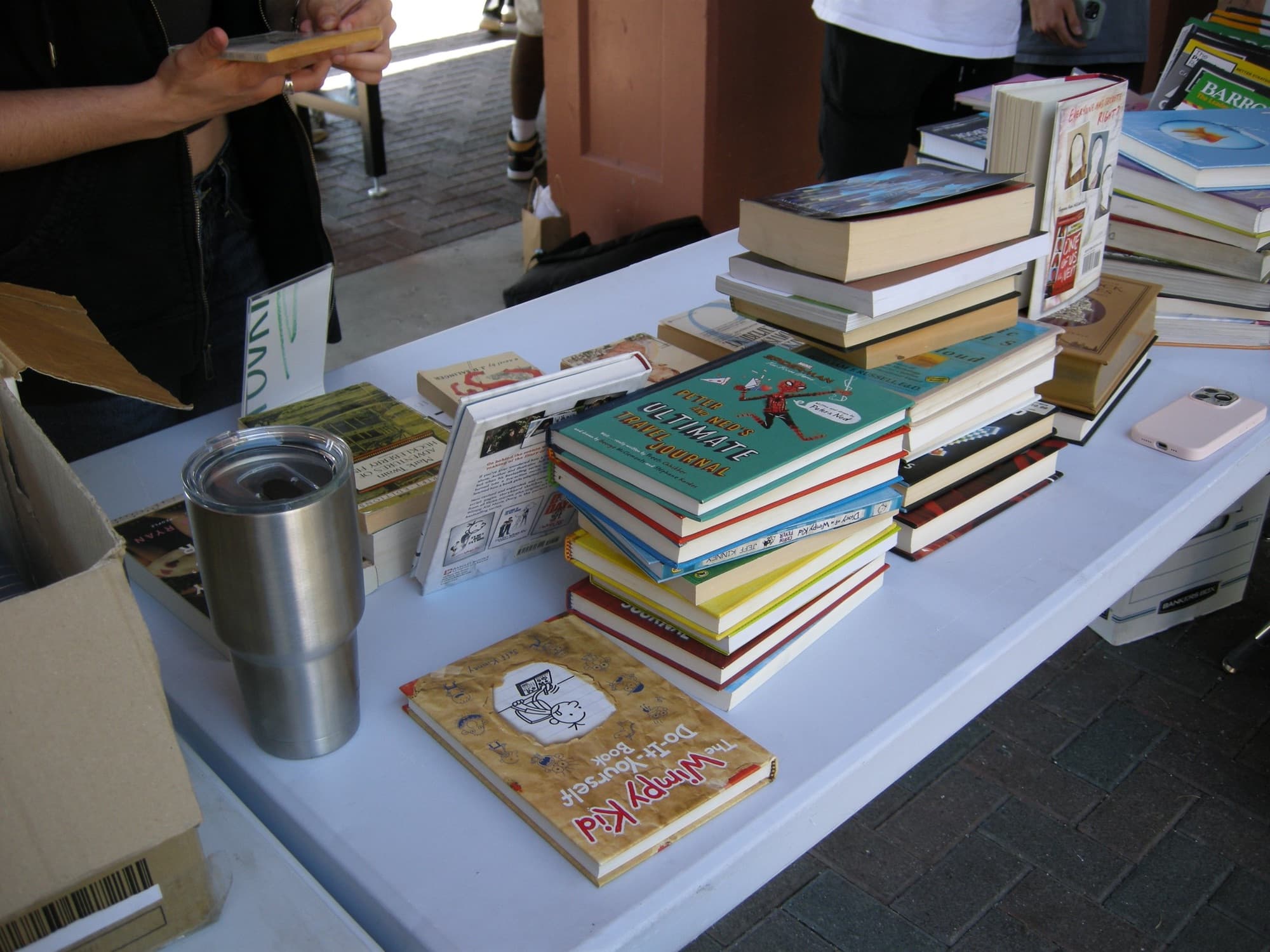 Donated books stacked and fanned out across a table at the sale.
