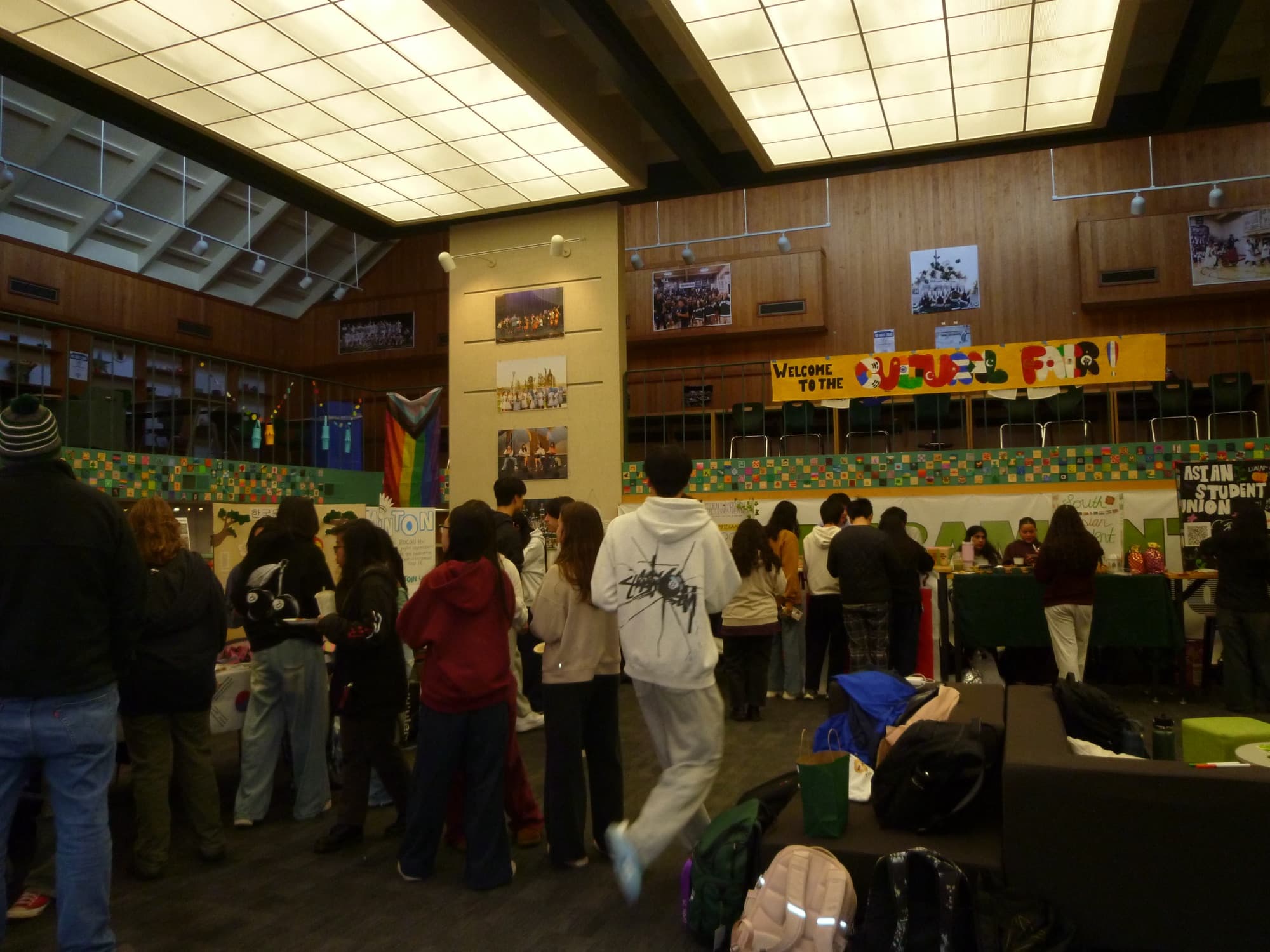 Students filling the Wellness Center at the Cultural Festival, beneath a hand-painted “Welcome to the Cultural Fair” banner.